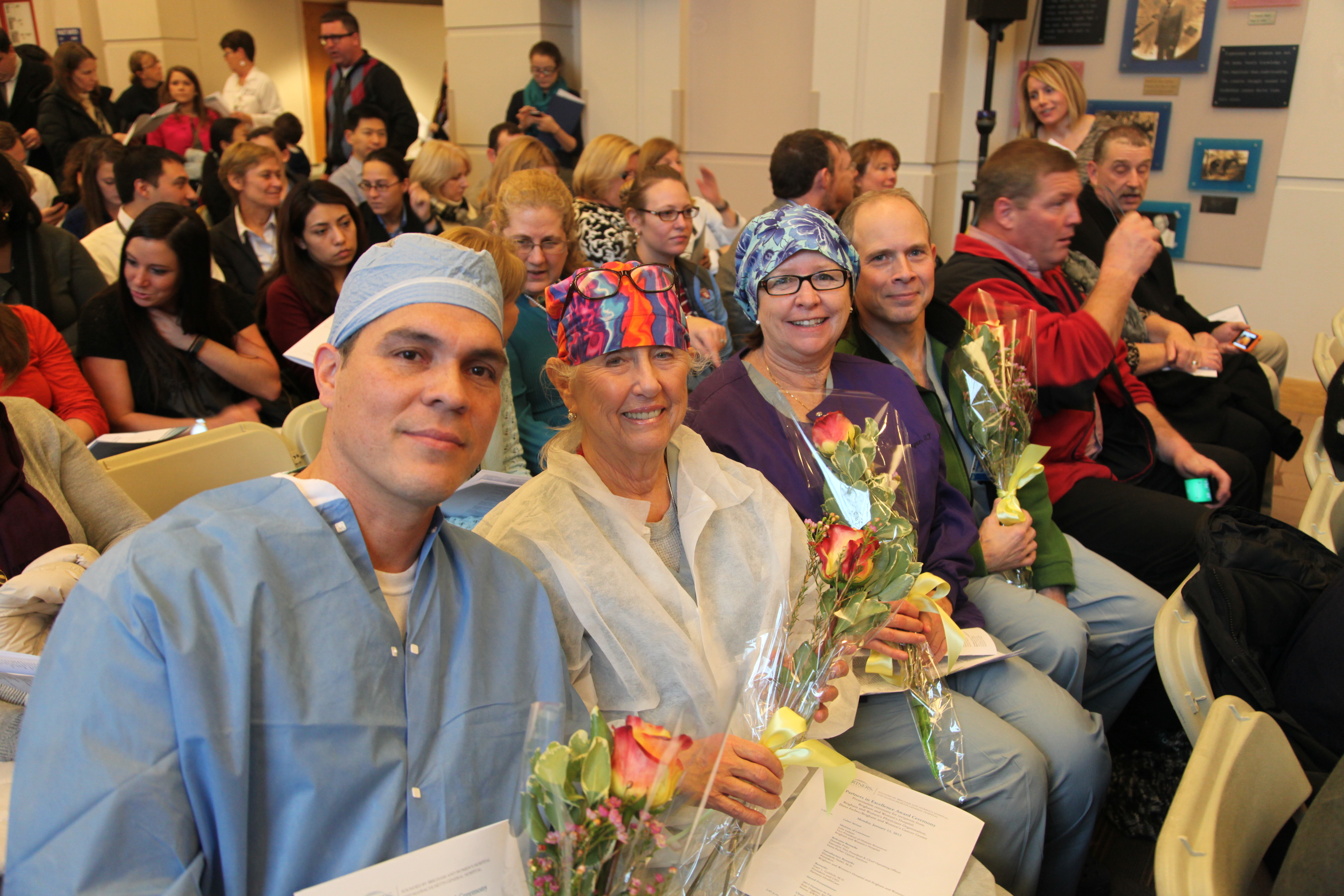 At left, from left: Diego Martinez, Donna Ward, Patty Bryan and Eugene Dziedzic, of the Hybrid Interventional Obstetrical Surgery Team, which received a PIE award. At right: PIE award recipient Ciola Bennett, of BWH Care Coordination, poses with Partners President Gary Gottlieb and Betsy Nabel.