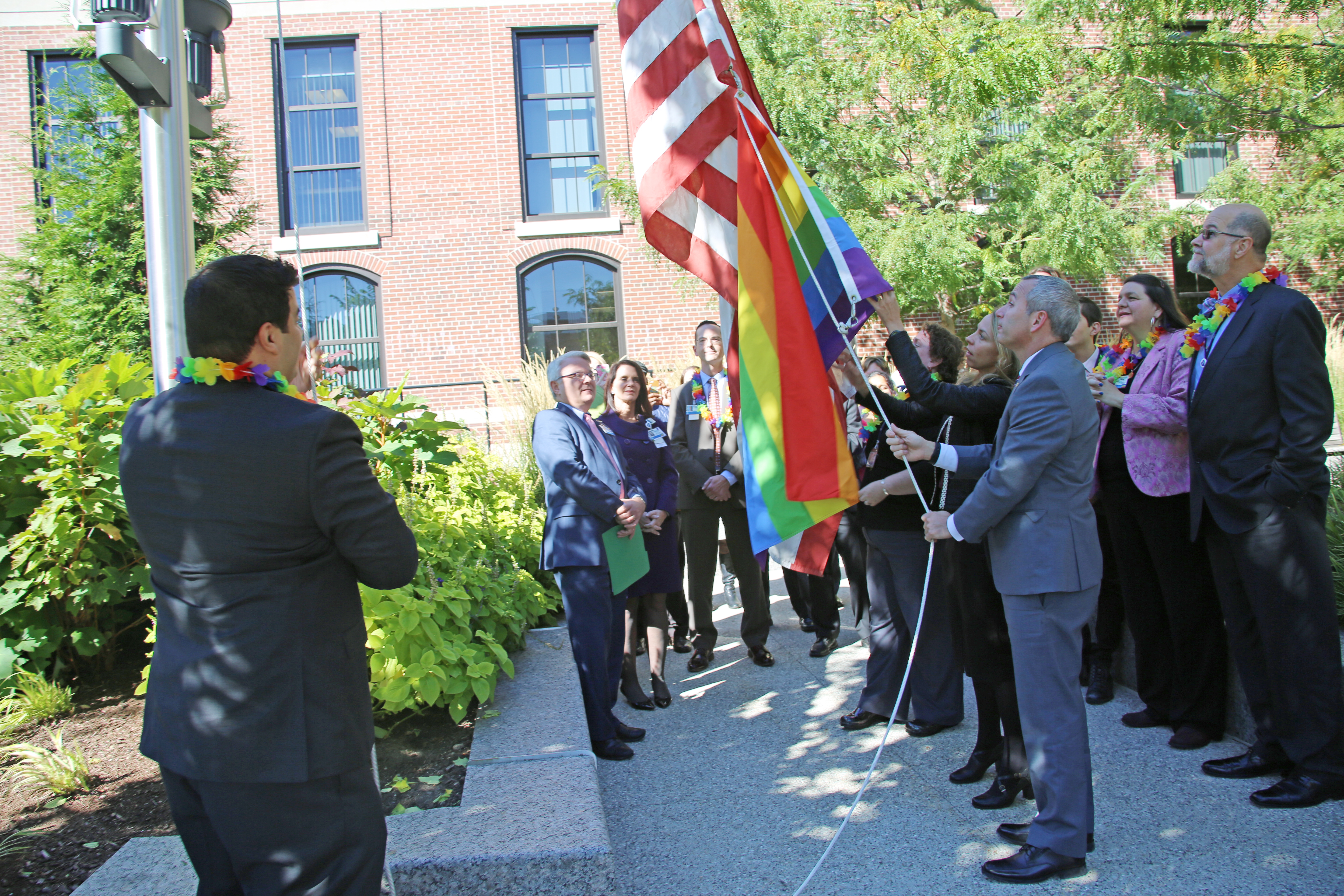 Members of the BWHC LGBT & Allies Employee Resource Group help raise a rainbow flag outside 15 Francis St.