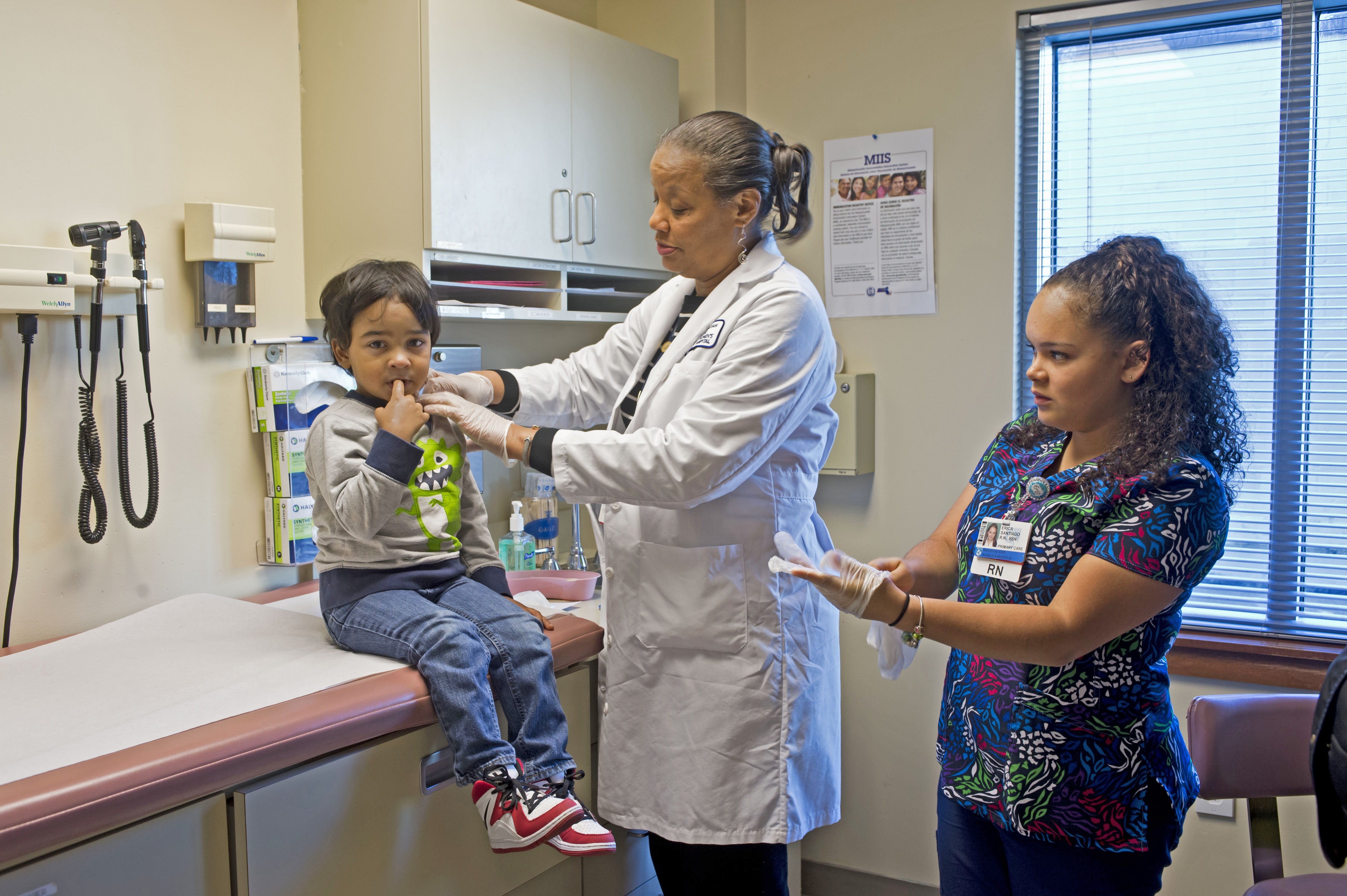 From left: A young patient at Southern Jamaica Plain Health Center is cared for by Regina Harvey and Erica Santiago.