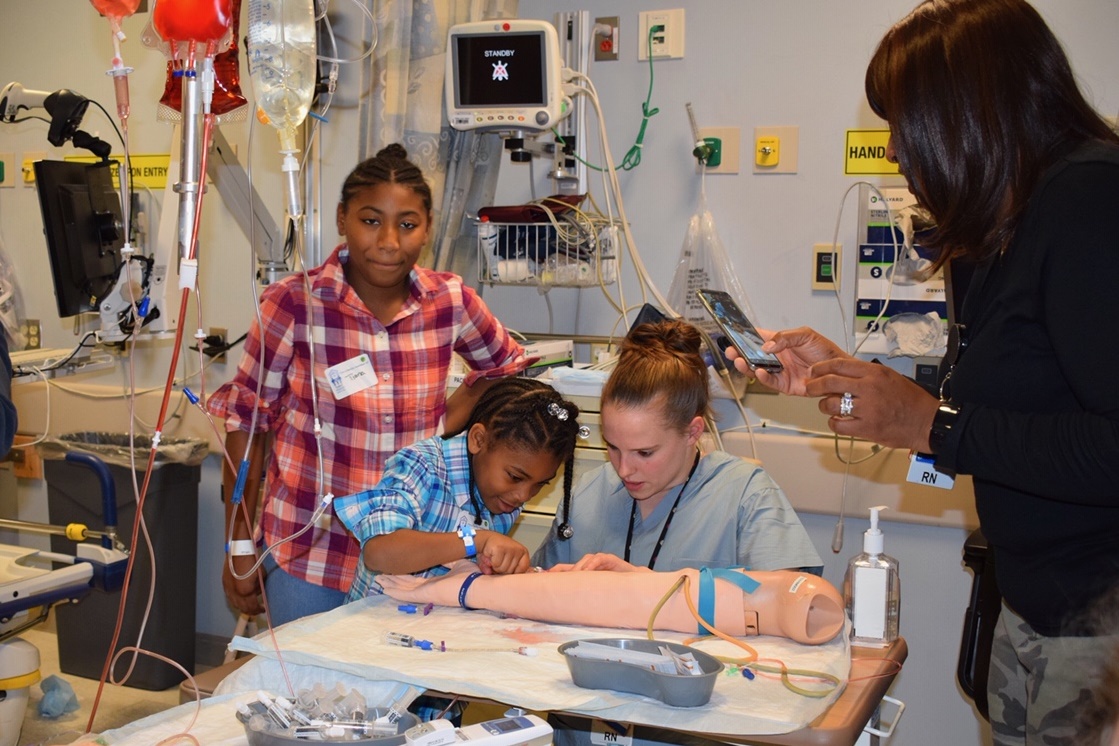 children participating in family day at the hospital by trying out simulation items.
