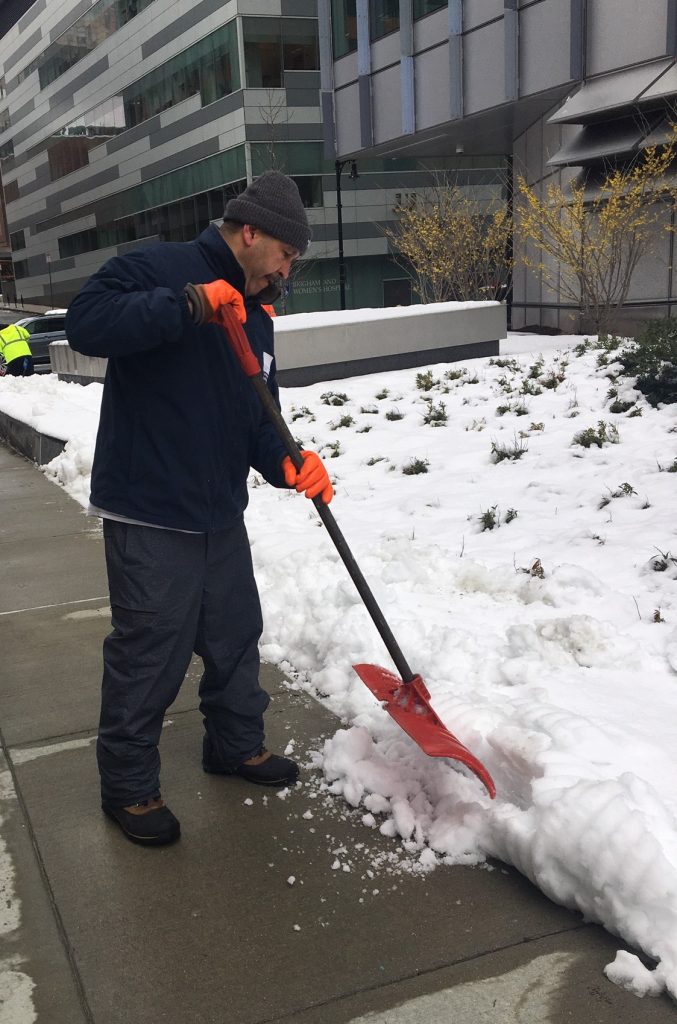 Ruberkis Arias, of Environmental Services, shovels snow outside the Hale Building for Transformative Medicine.