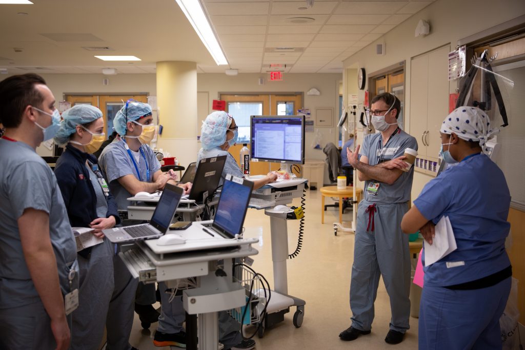 Providers meet outside a patient room.