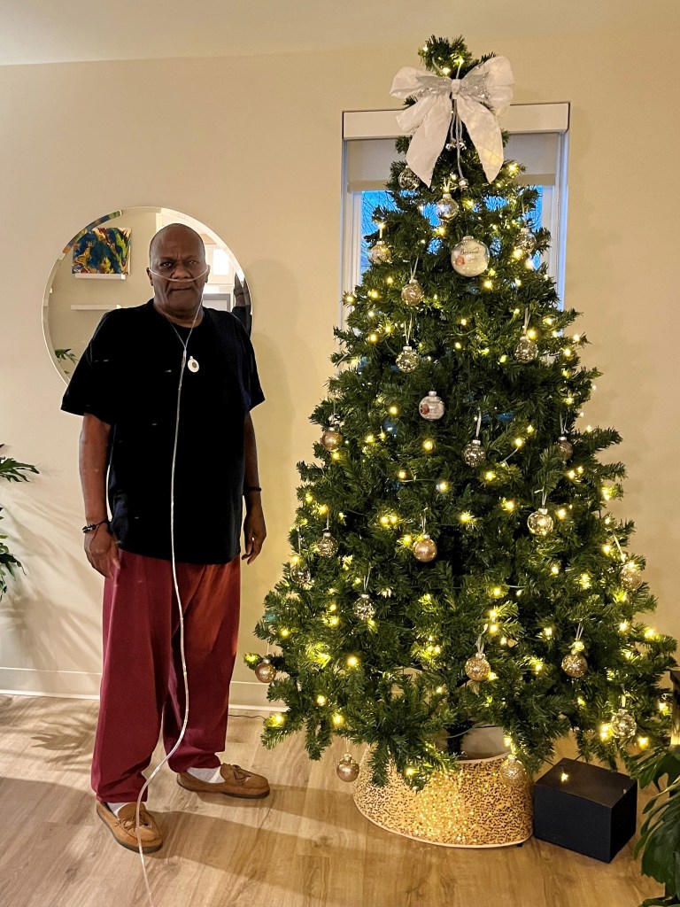 Man standing next to Christmas tree