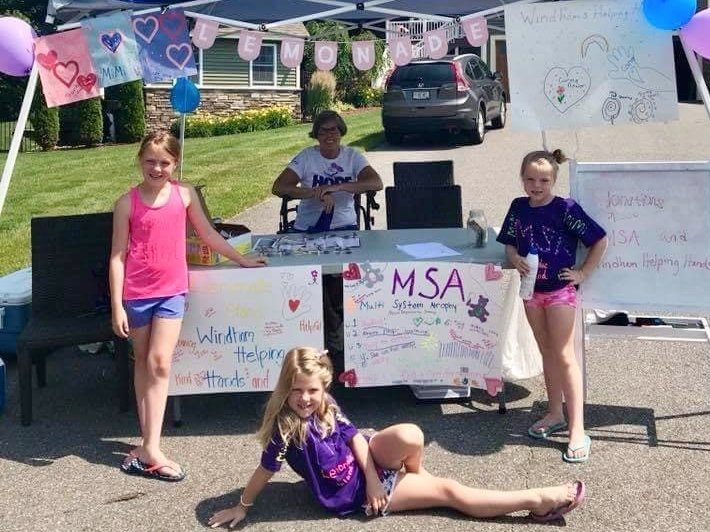 Three children and their grandmother at a lemonade stand
